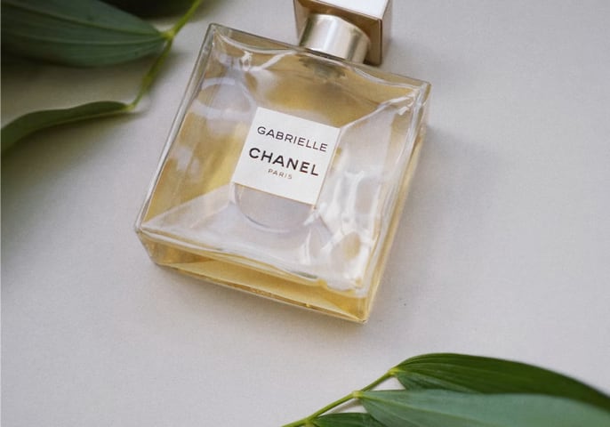 A bottle of parfum surrounded with leafs